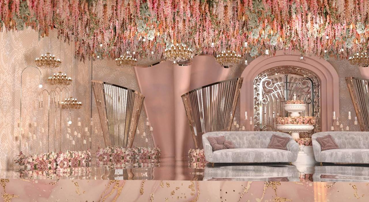 Blush pink reception lounge with hanging floral strings and draped arches by RAW Group